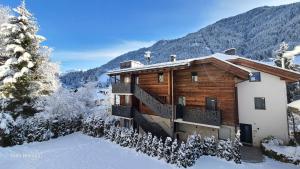 a log cabin in the mountains with snow on the ground at Villa Dolomiti in Ortisei