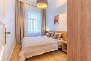 a small bedroom with a bed and a window at Picturesque Old Town Apartment with Charming Balcony in Kaunas