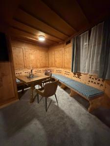 a room with a table and a bench and a window at FeWo's und Apartment's Blaues Haus in Davos