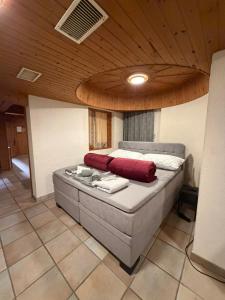 a large bed in a room with a wooden ceiling at FeWo's und Apartment's Blaues Haus in Davos +95 photos
