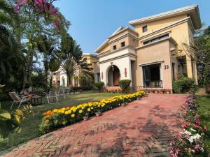 a building with a bunch of flowers on a brick path at Gardenia 29 in Raichak