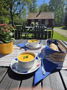 two bowls of soup sitting on a wooden table at Skagagården-peaceful stay near Tiveden National Park in Undenäs