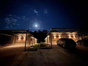 a car parked in front of two buildings at night at La Hojarasca in Termas de Guaviyú