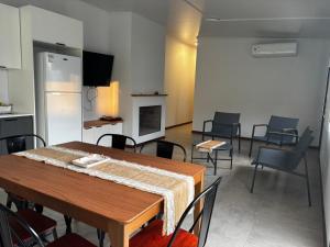 a room with a table and chairs and a kitchen at La Hojarasca in Termas de Guaviyú