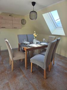 a dining room table with chairs and a clock on the wall at Zu-Haus in Peterdorf