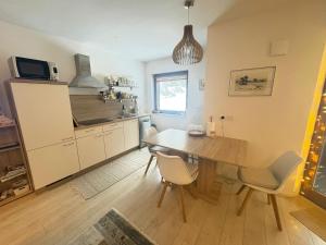 a kitchen with a wooden table and a dining room at Triglav NP Apartment - above Bled in Zgornje Gorje