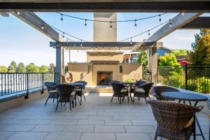 a patio with tables and chairs and a fireplace at The Lodge at Columbia Point in Richland