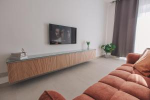 a living room with two couches and a flat screen tv at Seaside Luxury Home with Rooftop Pool in Birżebbuġa