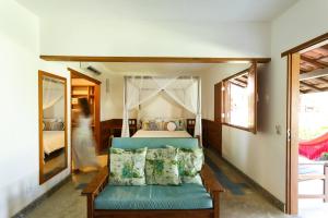 a bedroom with a bed with a blue couch at Pousada Vila do Beco in Arraial d'Ajuda +59 photos