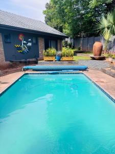 a large blue swimming pool in front of a house at The Chalant in Tzaneen
