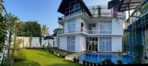 a house with a swimming pool in front of it at Yellow Rose Hotel in Kandy