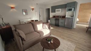 a living room with a couch and a table at Hôtel Le Chalet in Ax-les-Thermes