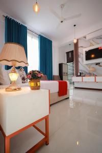 a bedroom with a bed and a table with a lamp at Yellow Rose Hotel in Kandy