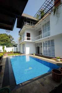 a large swimming pool in front of a building at Yellow Rose Hotel in Kandy