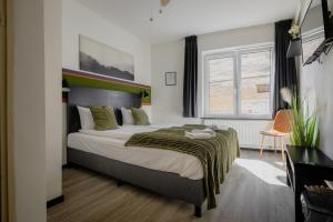 a bedroom with a bed with a green blanket at Le Bistro in Valkenburg