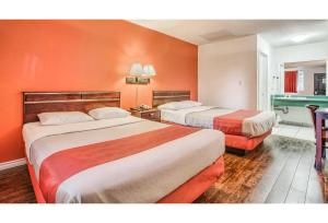 a hotel room with two beds with orange walls at Motel 6-Windsor, ON in Windsor