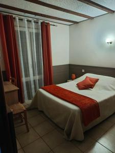 a bedroom with a large bed with red curtains at La barque aux Romarins in Orange