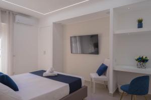 a bedroom with a bed and a tv on a wall at Suite Benvenuti al Sud in Crotone