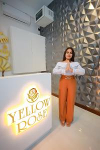 a woman is standing next to a yellow dog sign at Yellow Rose Hotel in Kandy +60 photos