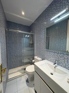 a bathroom with a toilet and a sink and a shower at Apartamentos Nouvilas in Portbou +50 photos