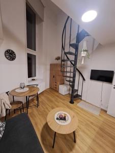 a living room with a spiral staircase and tables at ApartmánPohoda in Opava