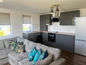 a living room with a couch and a kitchen at Upper Valley View in Keynsham