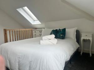 a bedroom with a large white bed with pillows at Upper Valley View in Keynsham