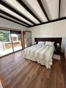 a bedroom with a bed and a wooden floor at Ecoraleo in Concepción +35 photos