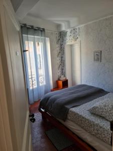 a bedroom with a bed and a window at Chambre bleue La Baieta in Moulinet