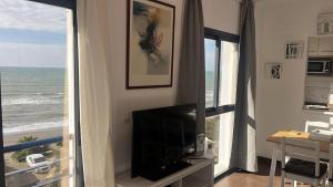 a living room with a television and a view of the ocean at over the sea in El Morche