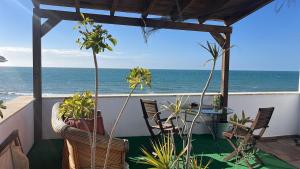 a balcony with a table and chairs and the ocean at over the sea in El Morche