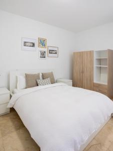 a white bedroom with a large white bed at Modern Ground Level, 4 BR condo in Palm-Eagle Beach +36 photos