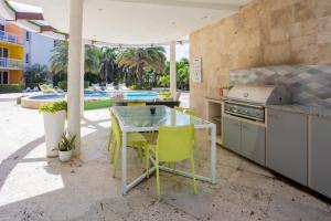 an outdoor kitchen with a table and chairs and a pool at Modern Ground Level, 4 BR condo in Palm-Eagle Beach