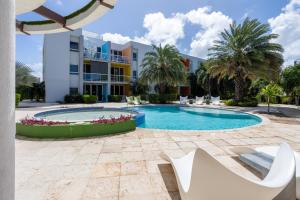 a swimming pool in front of a building at Modern Ground Level, 4 BR condo in Palm-Eagle Beach