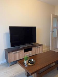 a living room with a flat screen tv on a entertainment center at Rodzinna Przystań in Białystok