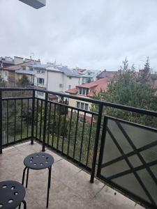 a balcony with two chairs and a view of buildings at Rodzinna Przystań in Białystok