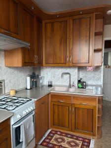 a kitchen with wooden cabinets and a sink at Rodzinna Przystań in Białystok