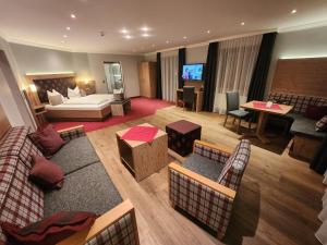 a living room with a couch and a bed and a television at Hotel Seeblick in Bad Reichenhall +68 photos