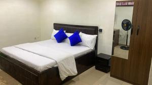 ein Bett mit blauen Kissen in einem Zimmer in der Unterkunft Bolif Hotel in Abeokuta