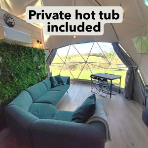 a living room with a blue couch and a table at Little River Glamping in Ballymoney