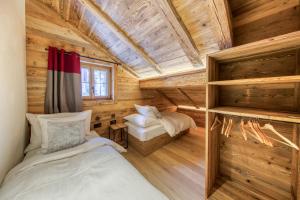 a bedroom in a log cabin with a bed and a window at Central High-End Duplexes, Sauna and Stove in Champéry