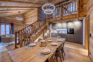 a dining room with a long table and chairs at Central High-End Duplexes, Sauna and Stove in Champéry