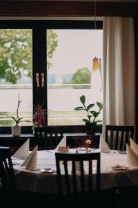 a dining room with a table and a large window at Hotel & Restaurant Friedrichshöhe in Braunschweig