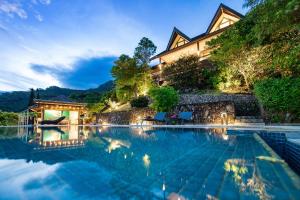 a house with a swimming pool in front of a house at Villa Manatea in Teavaro