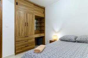 a bedroom with a large wooden cabinet and a bed at Sitraka Résidence in Mahitsy