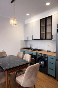 a kitchen with a table with chairs and a stove at Stylish House in Kutaisi