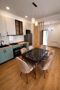 a kitchen and dining room with a table and chairs at Stylish House in Kutaisi