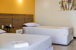 a hotel room with two beds and a phone at Tapajós Center Hotel in Santarém