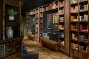 a library with several shelves of books at The MC, Autograph Collection in Montclair