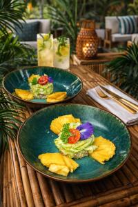 two plates of food on a wooden table at Tidododesiles in Bouillante +104 photos